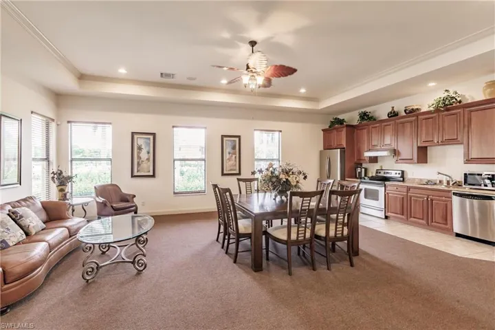 Tiled dining area with ceiling fan, a healthy amount of sunlight, and a tray ceiling