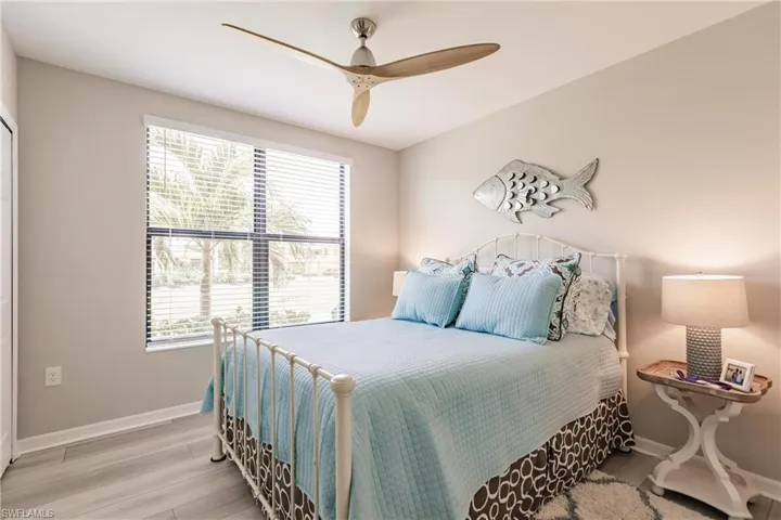 Bedroom featuring multiple windows, light wood-type flooring, and ceiling fan