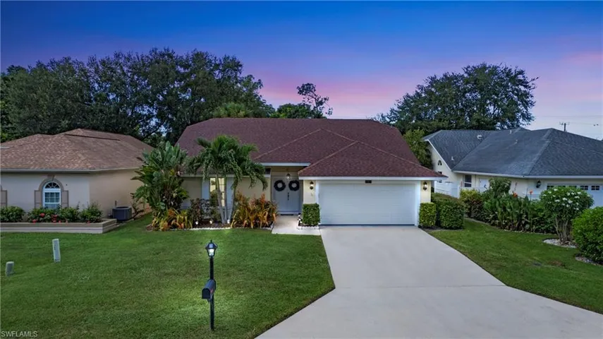 Ranch-style home featuring stucco siding, concrete driveway, and a front yard