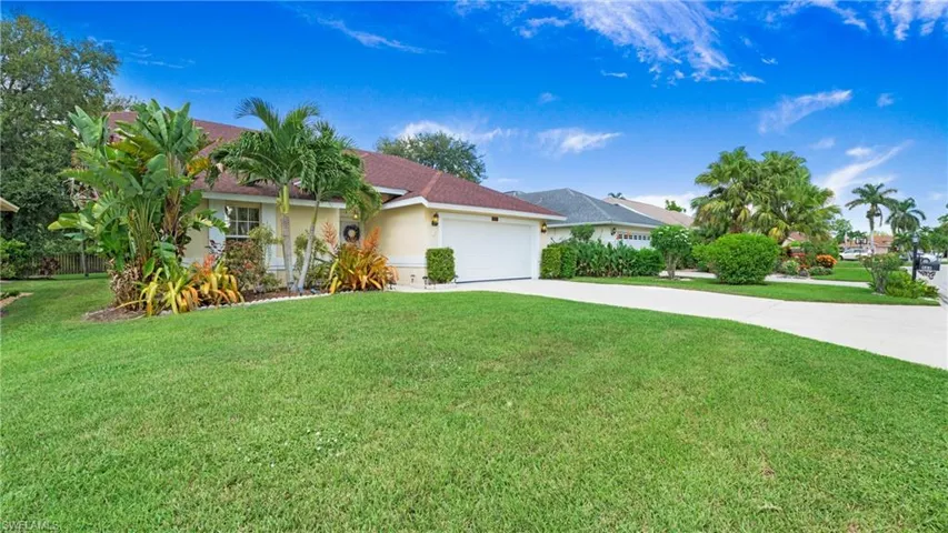 Single story home featuring stucco siding, concrete driveway, a front yard, a garage, and roof with shingles