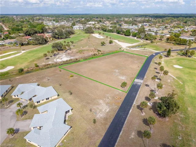 Aerial view of residential area with a golf course and property parcel outlined