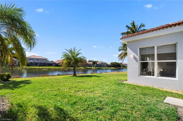 View of green lawn with a water view and a residential view