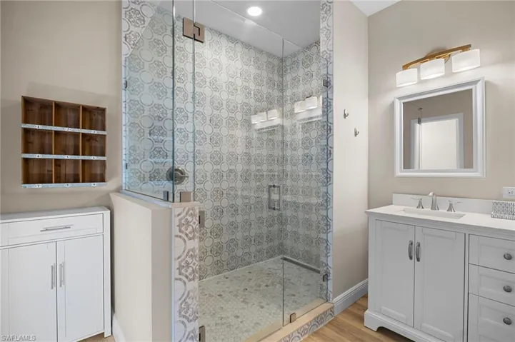 Bathroom featuring vanity, a shower stall, and light wood-style floors