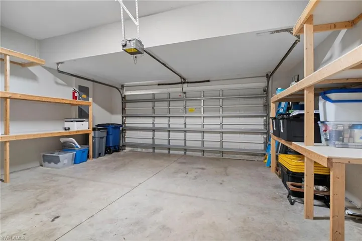 Garage featuring electric panel and a garage door opener