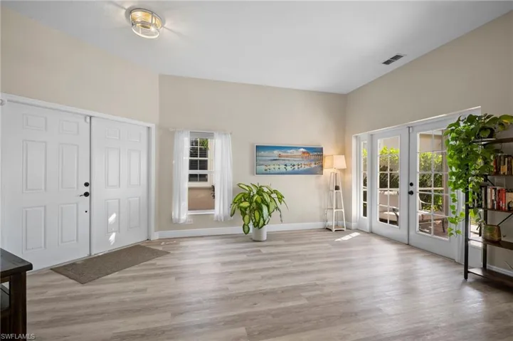 Entryway with french doors and light wood-style floors