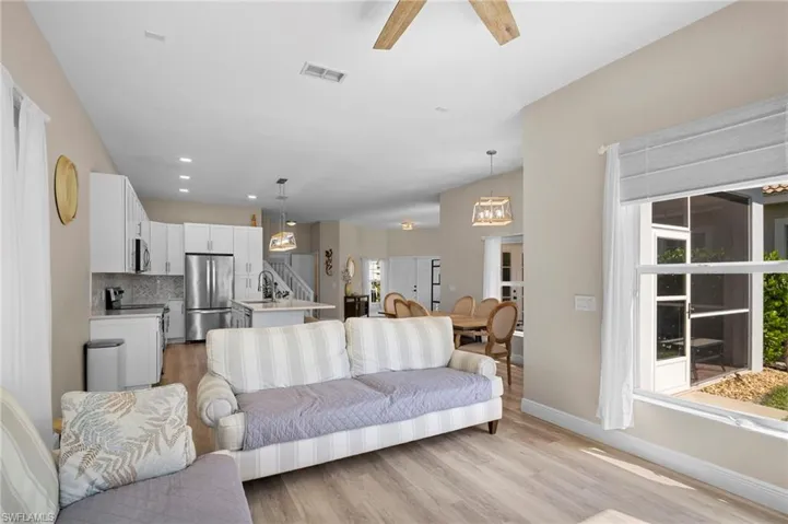 Living area with light wood-style flooring, a ceiling fan, and recessed lighting