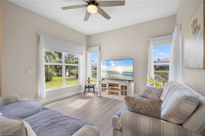 Living room featuring a ceiling fan, wood finished floors, and plenty of natural light