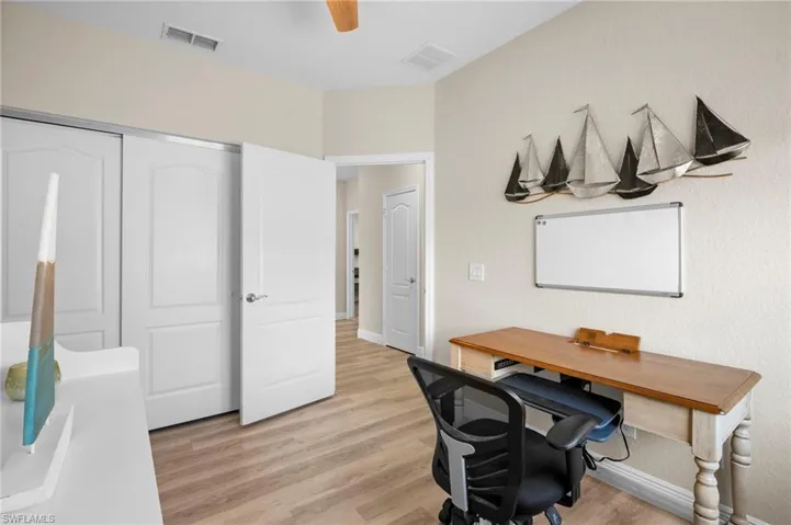 Home office with light wood finished floors and ceiling fan