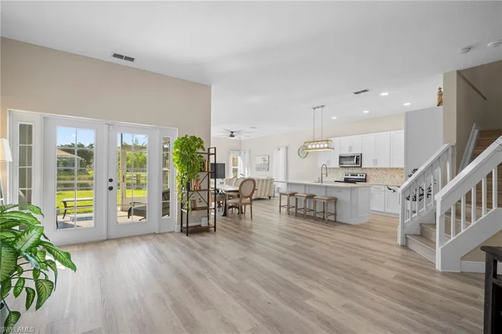 Living area with light wood finished floors, french doors, and recessed lighting