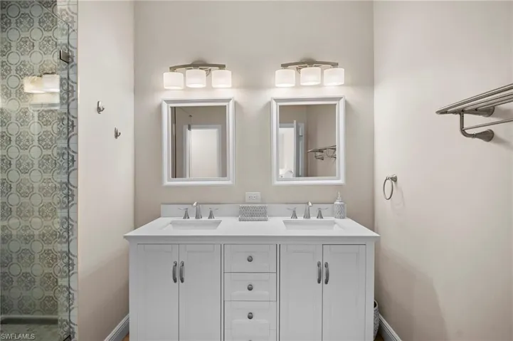 Full bath with double vanity and tiled shower