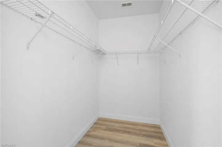 Walk in closet with light wood-style flooring