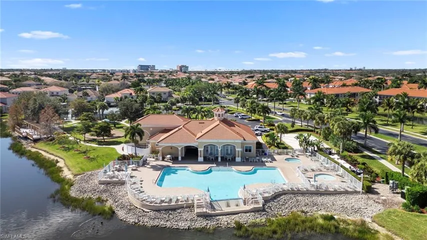 Community pool featuring a patio, a hot tub, a residential view, and a water view