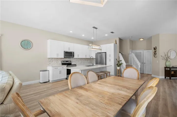 Dining room with stairs and light wood finished floors