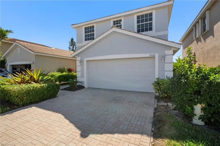 View of front of property with a garage, decorative driveway, stucco siding, and a tile roof