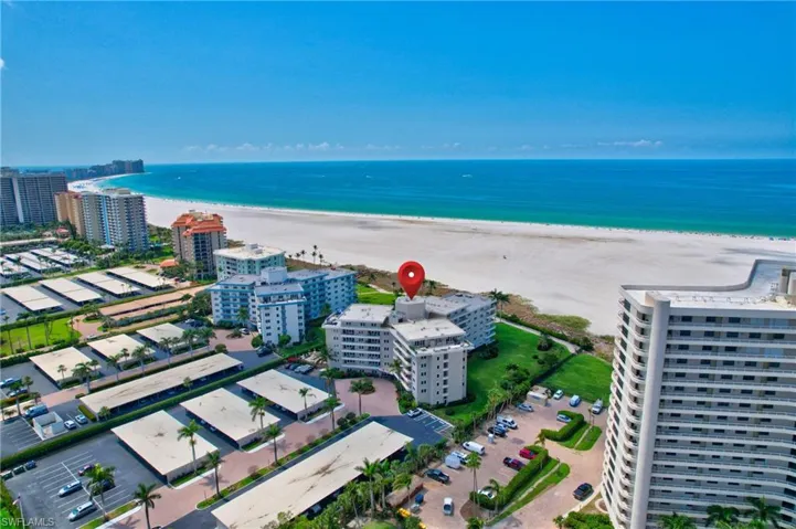 Birds eye view of property featuring a water view and a beach view