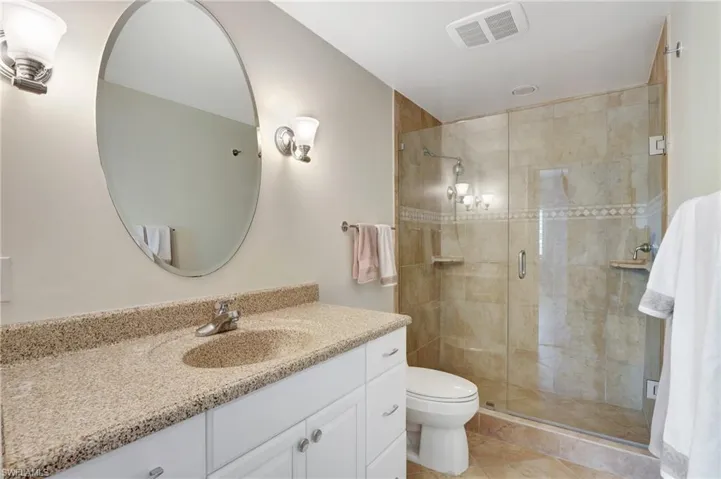 Bathroom featuring vanity, toilet, tile patterned flooring, and walk in shower