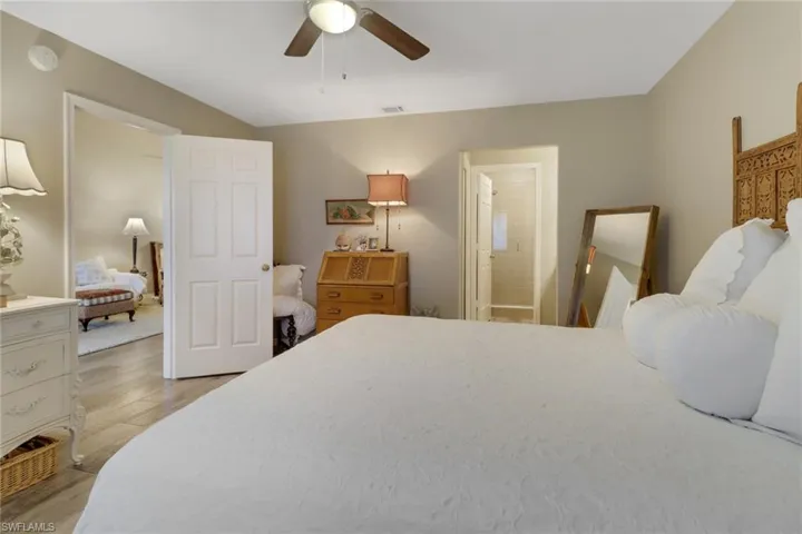 Bedroom with connected bathroom, ceiling fan, and light hardwood / wood-style flooring