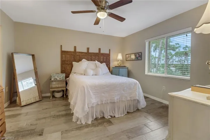 Bedroom featuring light hardwood / wood-style flooring, multiple windows, and ceiling fan