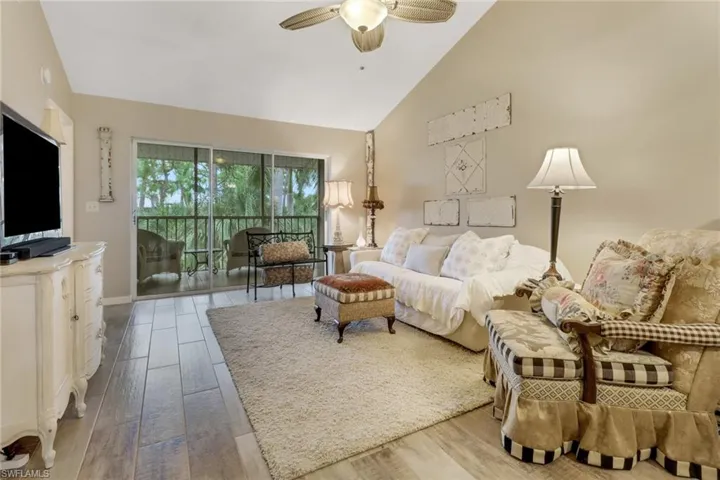 Living room featuring ceiling fan, light hardwood / wood-style flooring, and high vaulted ceiling