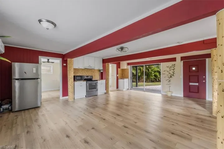 Unfurnished living room featuring ornamental molding and light hardwood / wood-style floors