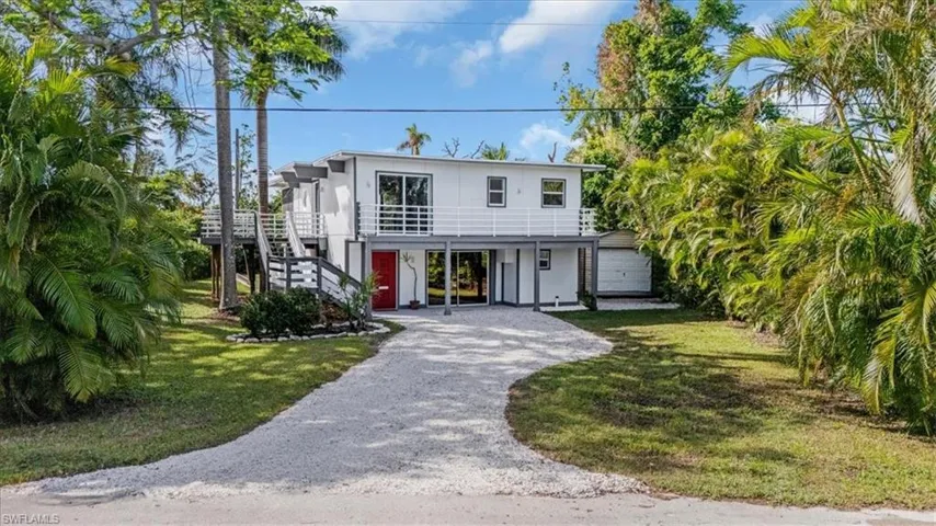 View of front facade with a garage, a front lawn, and a carport
