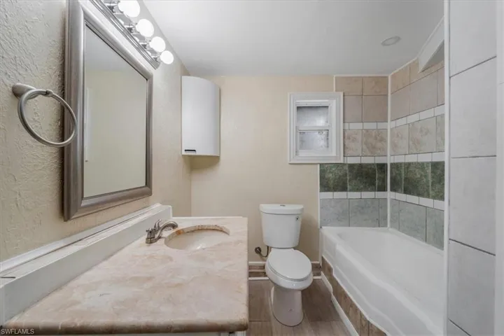 Bathroom featuring hardwood / wood-style flooring, vanity, and toilet