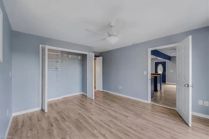 Unfurnished bedroom featuring light hardwood / wood-style floors, a closet, and ceiling fan