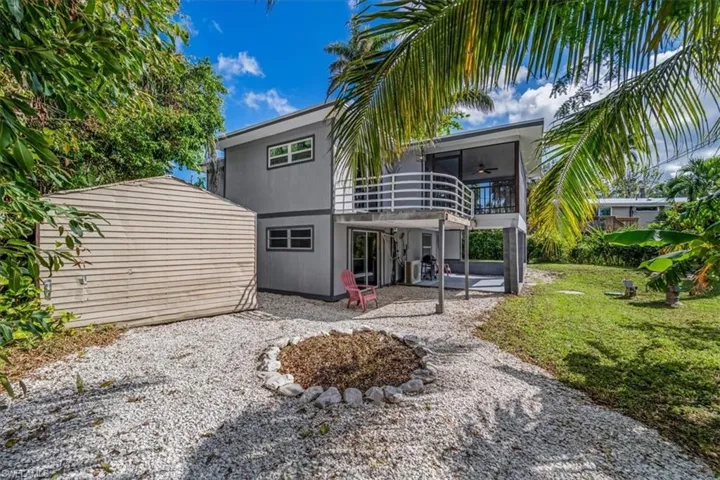 Rear view of property with a balcony, a lawn, ceiling fan, and a patio area