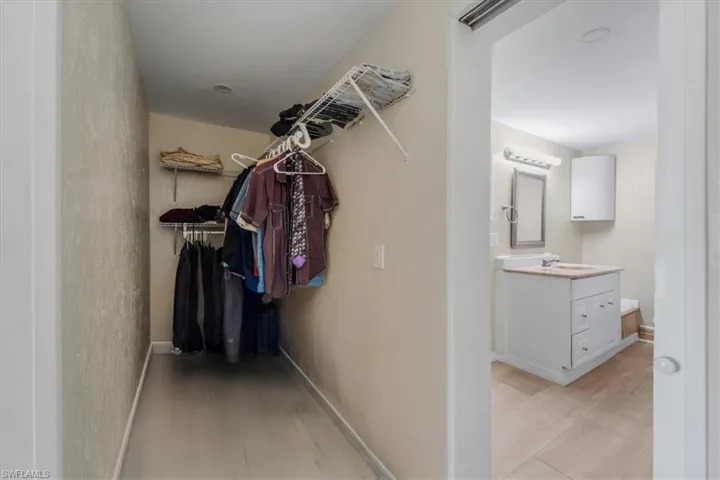 Walk in closet with light hardwood / wood-style floors and sink