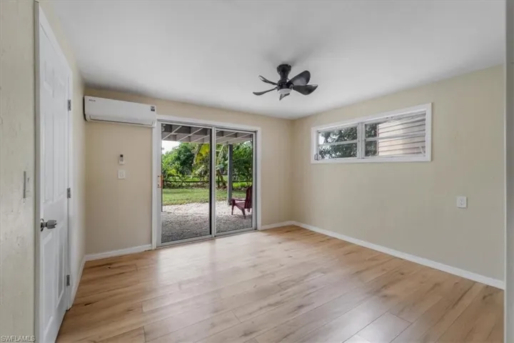 Empty room featuring ceiling fan, light hardwood / wood-style floors, and an AC wall unit