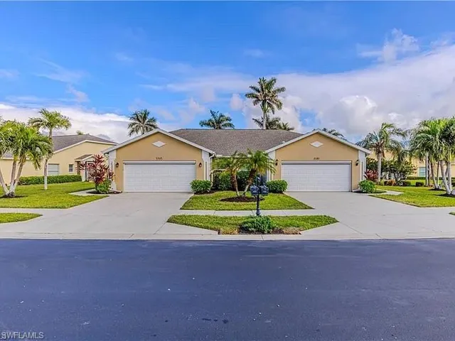 View of front facade featuring stucco siding, driveway, a front yard, and an attached garage
