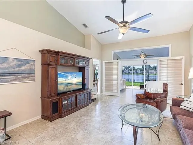 Living room with ceiling fan and high vaulted ceiling