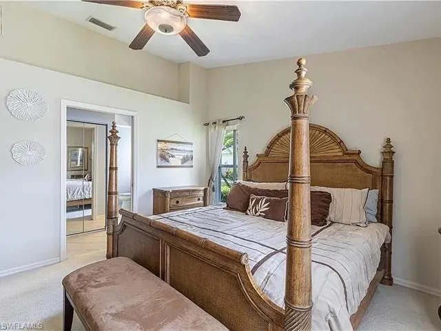 Bedroom featuring light carpet, ensuite bathroom, and a ceiling fan
