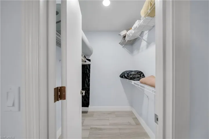 Utility closet featuring wood-finish tile flooring, white wire shelving, recessed lighting, and light gray wall paint