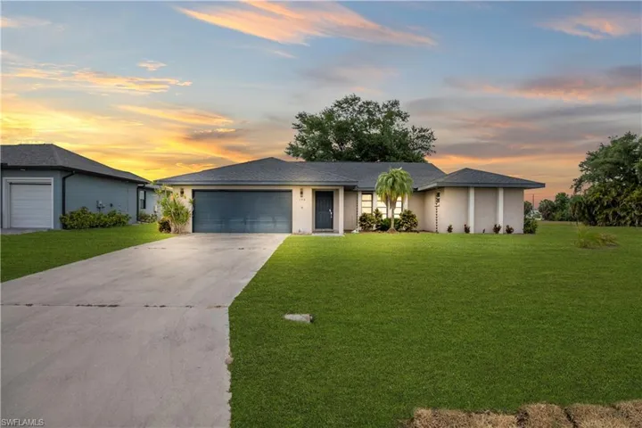 Contemporary single-story residence featuring a dark gray garage door, light-colored exterior siding, a shingled roof, a concrete driveway, and mature landscaping