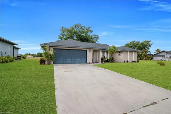 Single-story residence featuring a two-car garage, concrete driveway, and a shingle roof