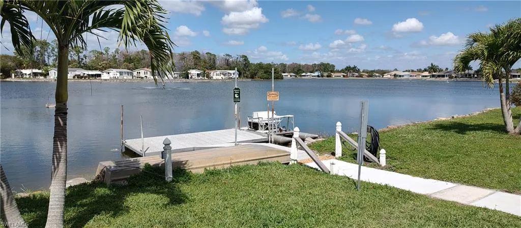 Dock area with a yard and a water view