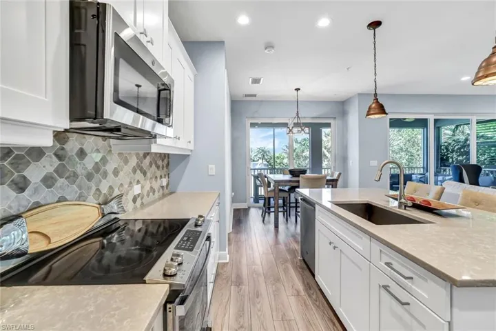 Kitchen featuring stainless steel appliances, light wood-style floors, a sink, and a healthy amount of sunlight