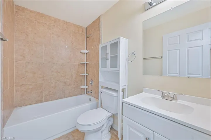 Guest Bathroom with shower / bathtub combination, vanity, and light tile patterned floors