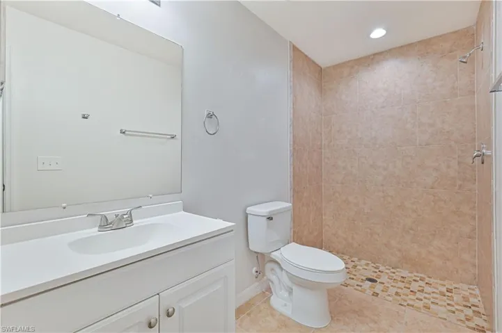 Master Bathroom featuring vanity, tiled shower, recessed lighting, and light tile patterned floors