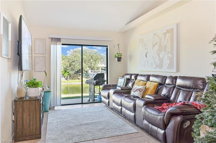 Living room with light tile patterned floors and lofted ceiling