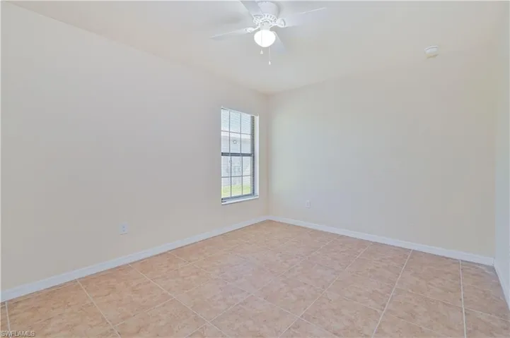 Spare room with ceiling fan and light tile patterned flooring