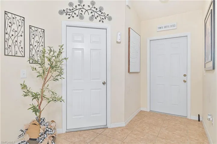 Unit #611 Foyer with light tile patterned floors and baseboards
