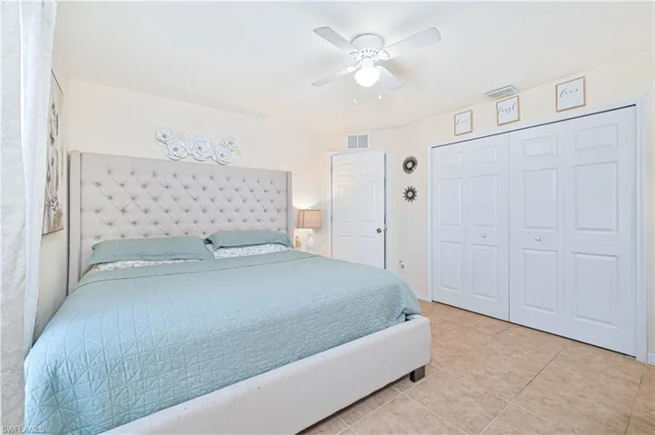 Bedroom with a ceiling fan, a closet, and light tile patterned floors