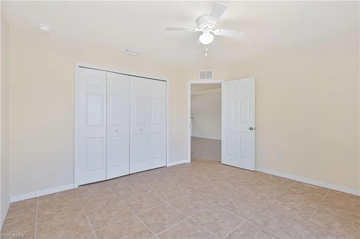 Unfurnished bedroom with a ceiling fan, a closet, and light tile patterned floors