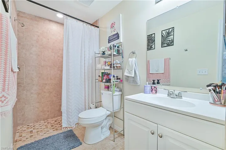 Master Full bath with tiled shower, vanity, light tile patterned flooring, and recessed lighting