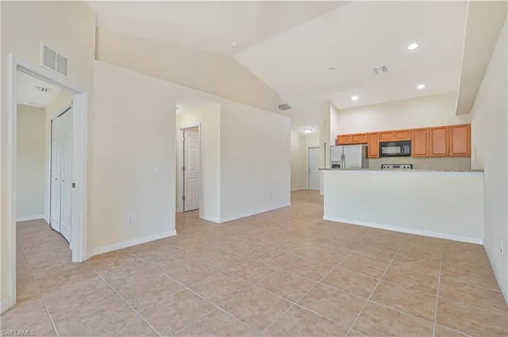 Unfurnished living room featuring recessed lighting, light tile patterned flooring, and high vaulted ceiling