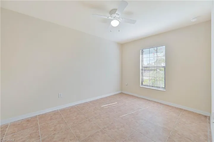 Spare room with a ceiling fan and light tile patterned floors