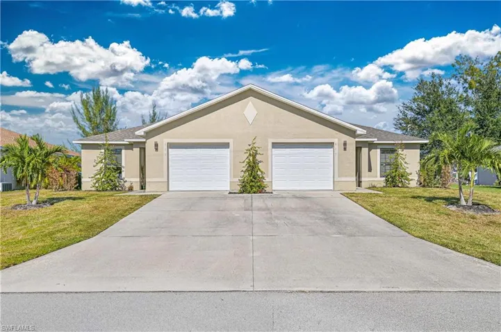 Single story home featuring a front lawn, stucco siding, and driveway