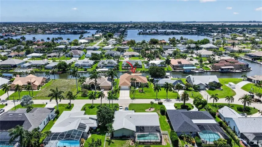 Waterfront community with extensive canal access, mature palm trees, and residential properties featuring private docks